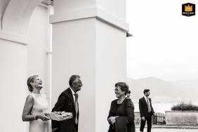 In Upper Austria, outside the church, the bride's parents warmly greet arriving guests, captured in a vintage-looking black-and-white photograph.